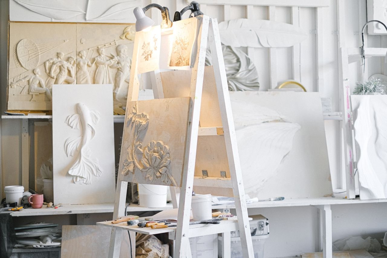 Art studio filled with diverse sculptures, tools, and materials, showcasing creativity and craftsmanship.